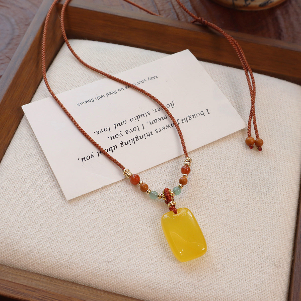 Ethnic Style Buddha Pendant Necklace For Adults With Yellow Braid And Chalcedony Inlay Featuring A Rope Woven Chain