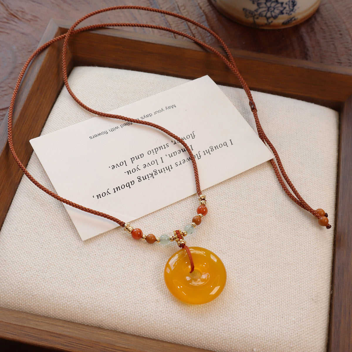 Ethnic Style Buddha Pendant Necklace For Adults With Yellow Braid And Chalcedony Inlay Featuring A Rope Woven Chain