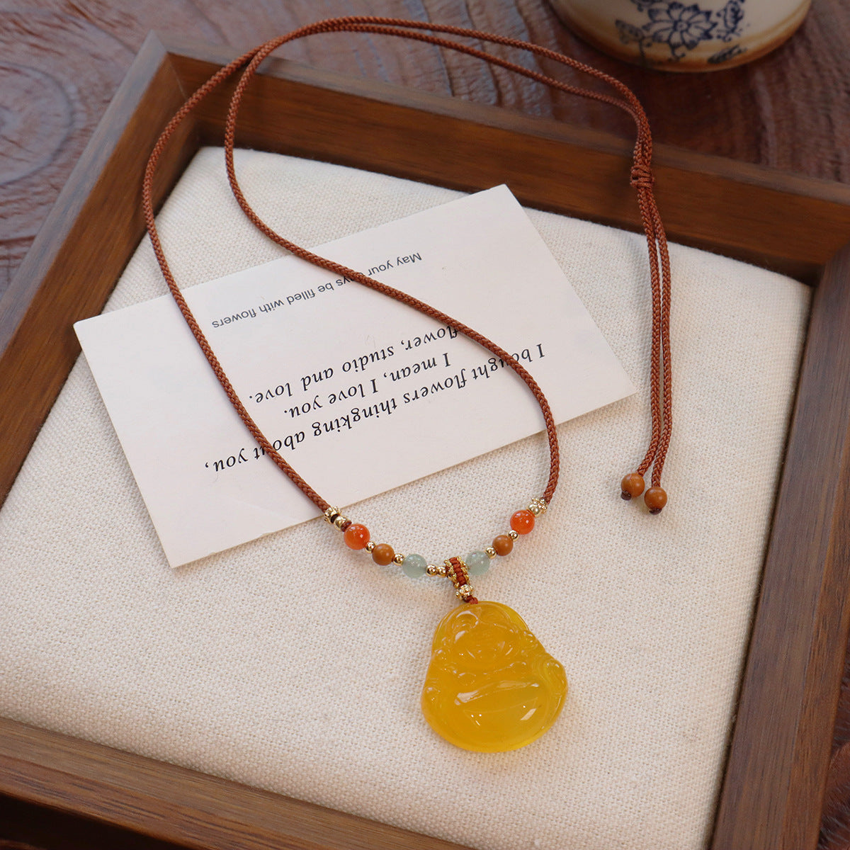 Ethnic Style Buddha Pendant Necklace For Adults With Yellow Braid And Chalcedony Inlay Featuring A Rope Woven Chain